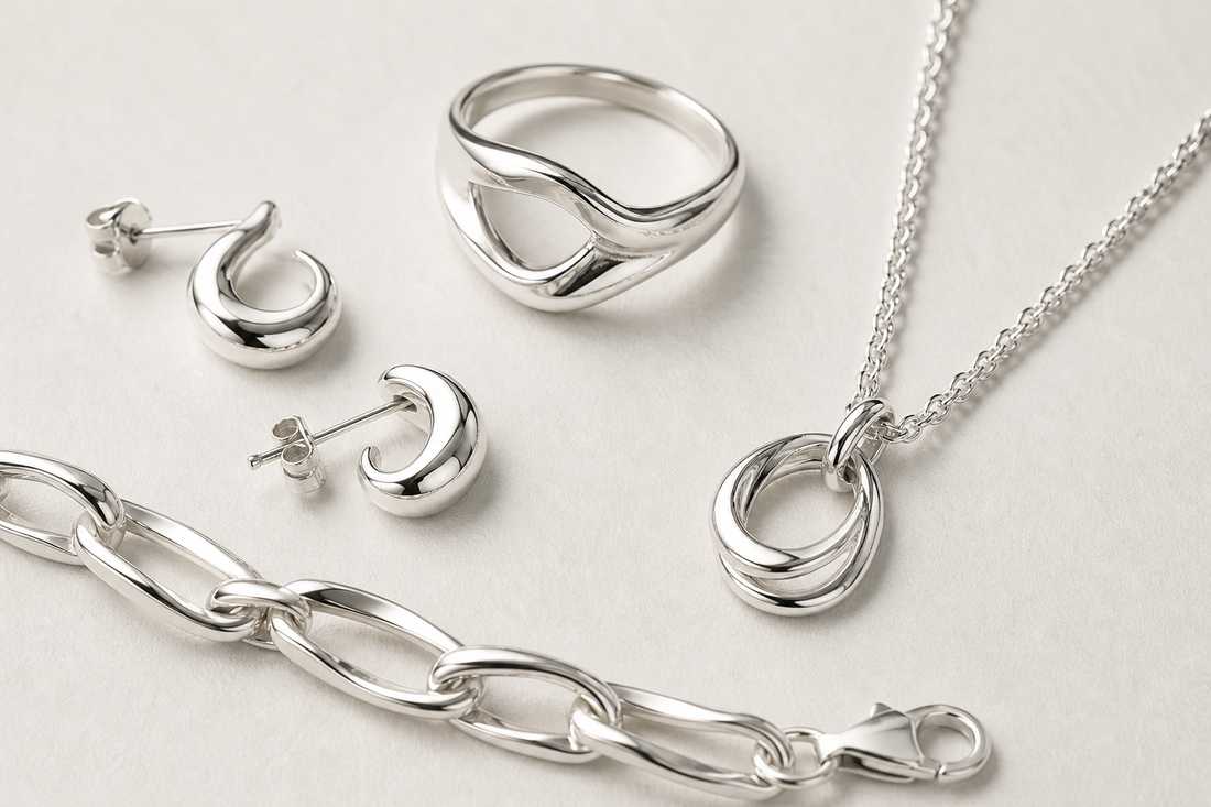 Sterling silver ring, earrings, bracelet, and necklace arranged on a light background